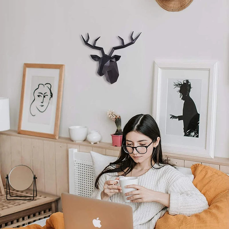 Woman sitting on a couch with a laptop and mug, surrounded by decorative items in a cozy room.