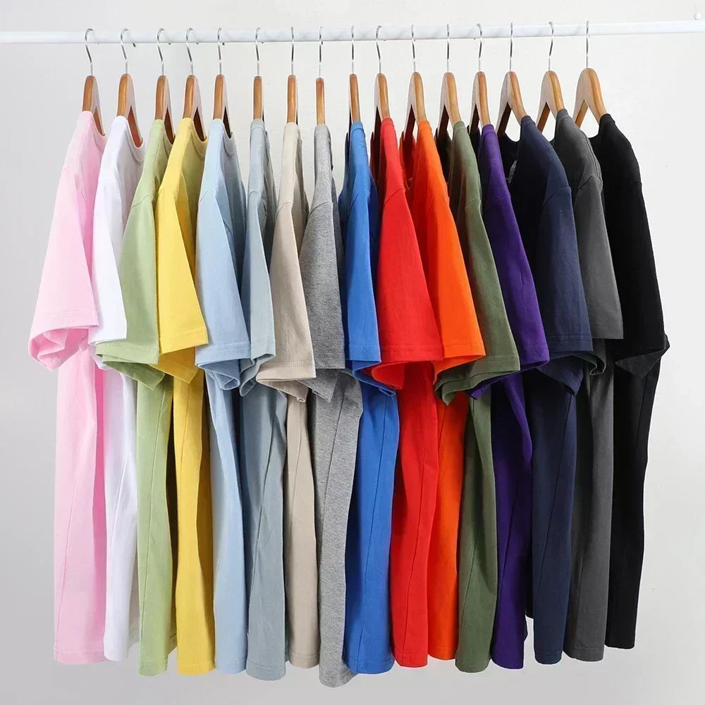 Row of colorful t-shirts on hangers against a white background