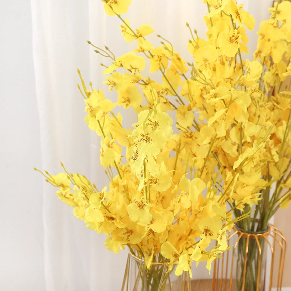 Bouquet of yellow flowers in a clear vase against a white background