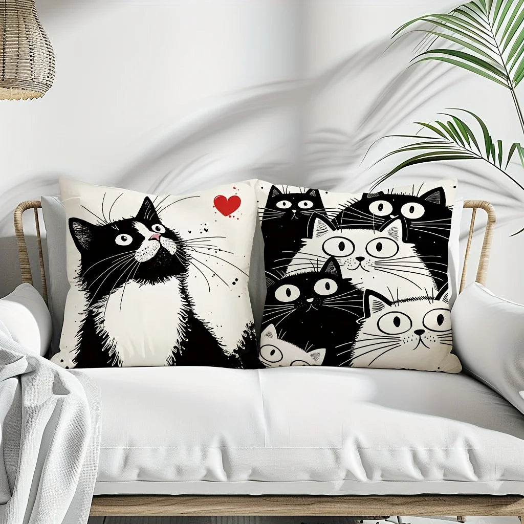 Set of cat-themed decorative pillows on a white sofa with a plant in the background.