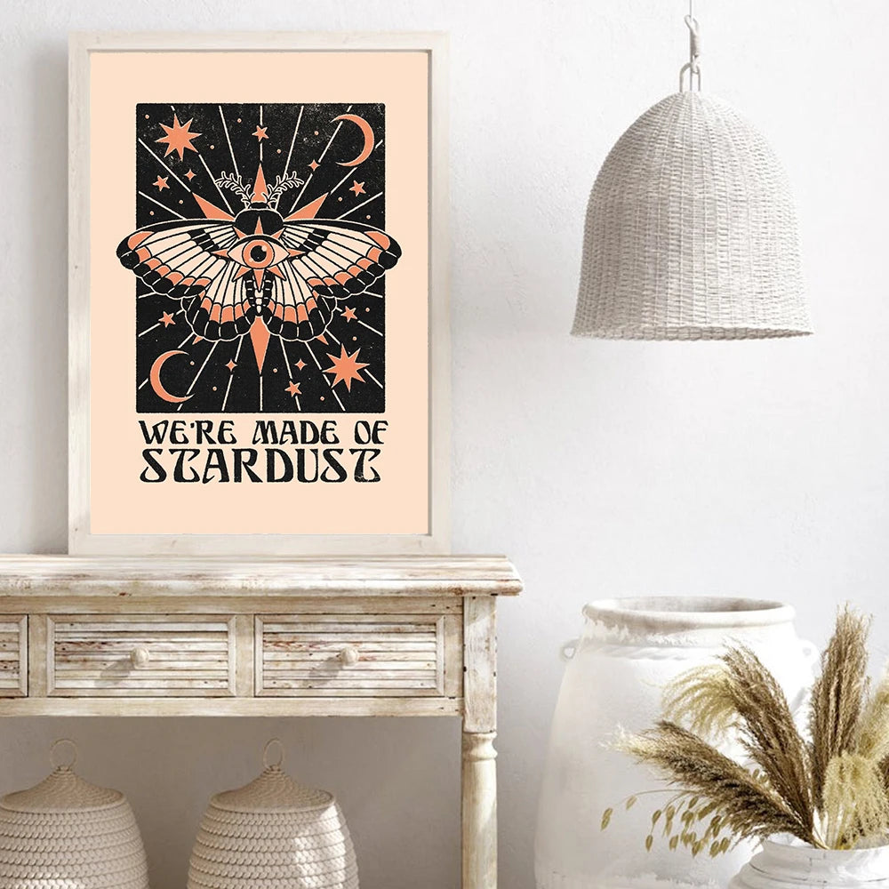 Framed artwork with celestial design and 'We're Made of Stardust' text on a wall above a wooden console table.