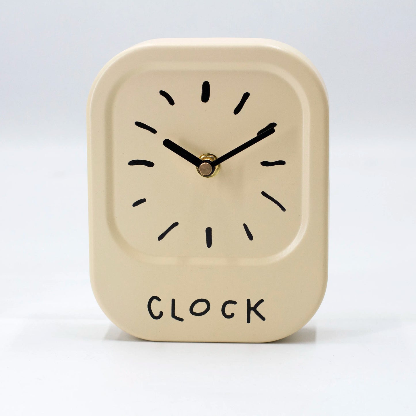 Beige clock with black hands and 'CLOCK' text on a white background