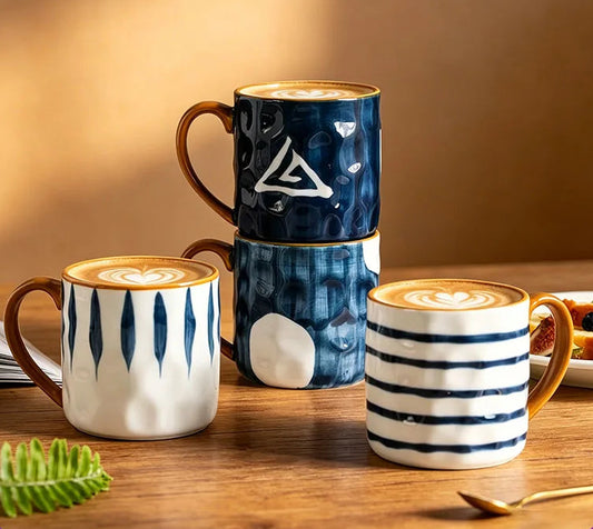 Three ceramic mugs with different designs on a wooden surface