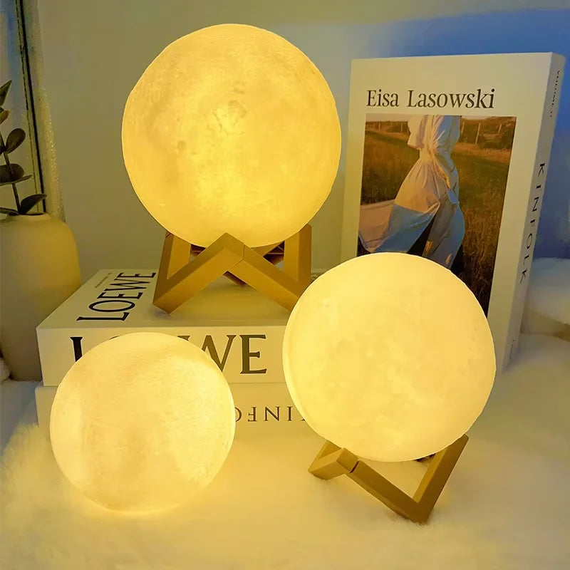 Three moon-shaped lamps on stands with a book titled 'Eisa Lasowski' in the background.