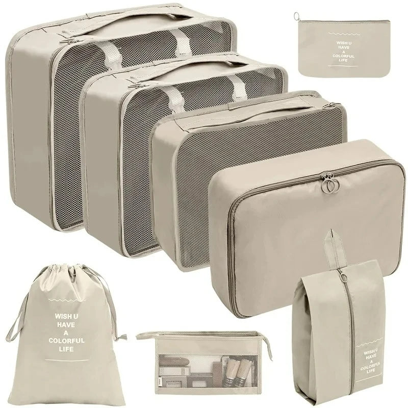 Set of beige packing cubes and travel bags with various designs and text.
