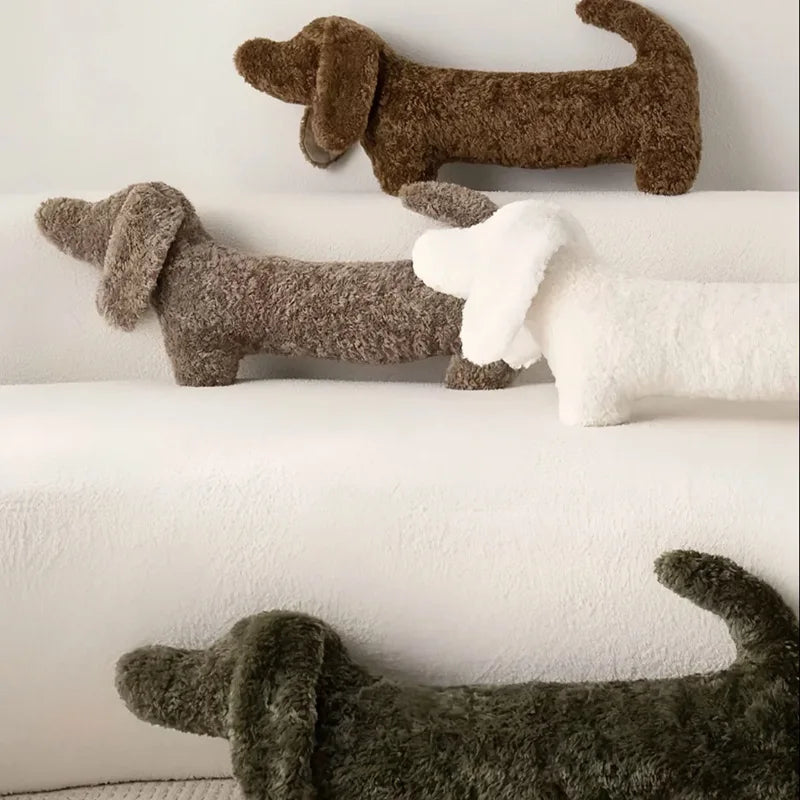 Three plush dachshund toys on a white surface