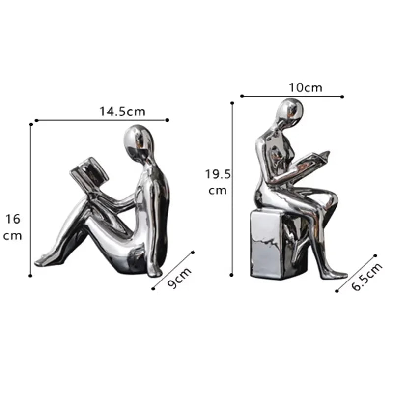 Two metallic sculptures of people sitting on boxes with dimensions indicated.