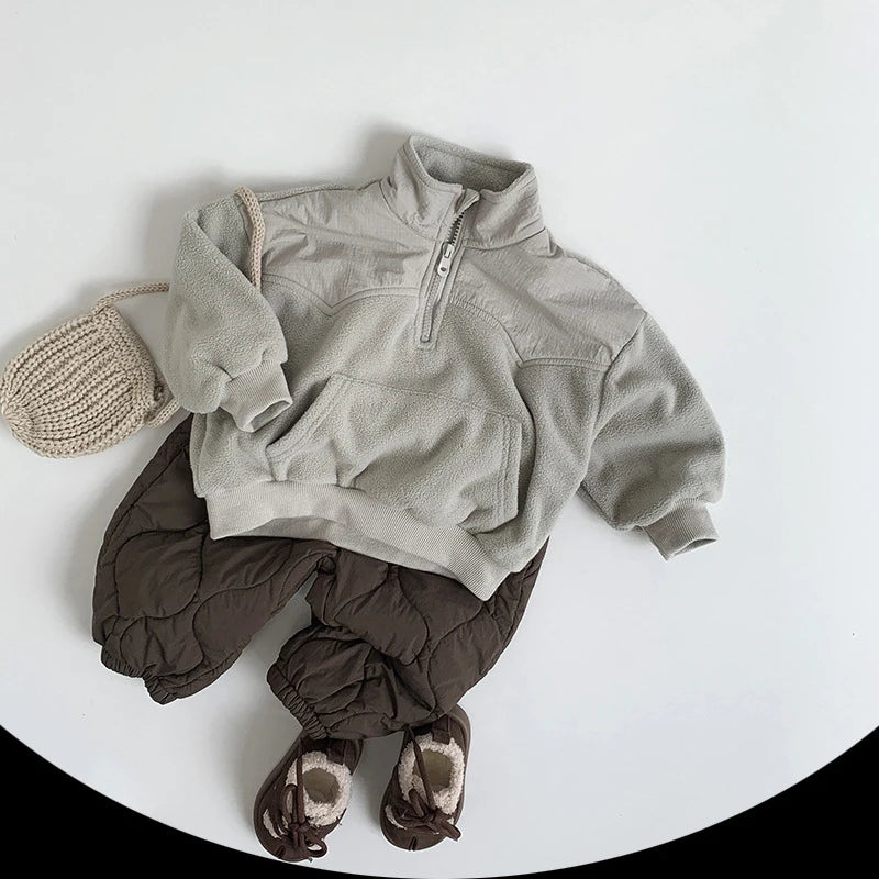 Children's winter outfit with a gray jacket, brown pants, and matching hat on a white background