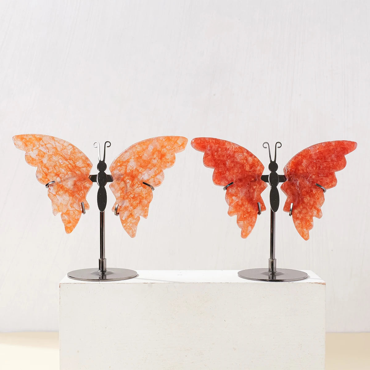 Butterfly wing sculptures on stands against a white background