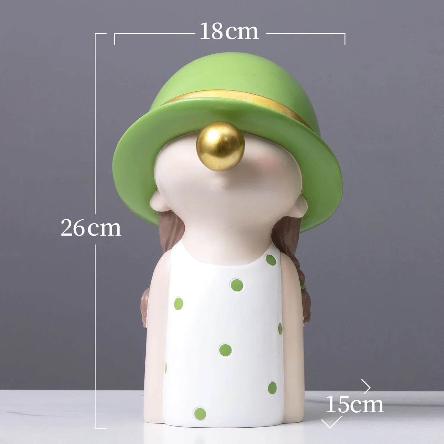 Decorative figurine with a green hat and polka dot dress, shown with measurements on a gray background.