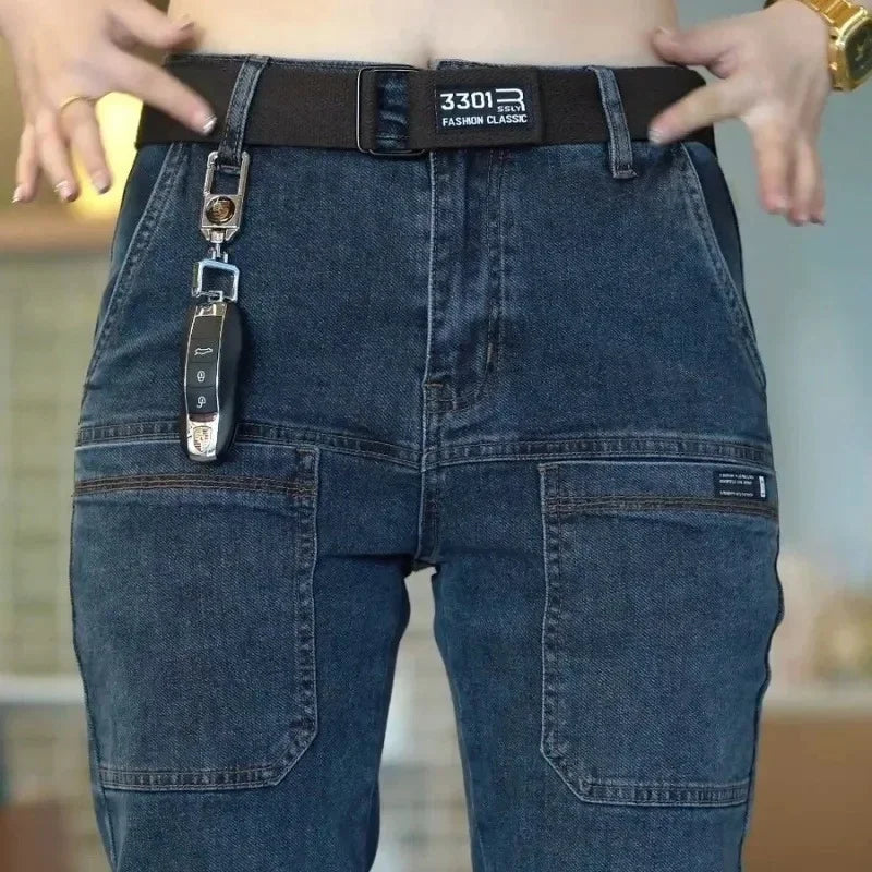 Person wearing blue jeans with a keychain and belt, blurred background