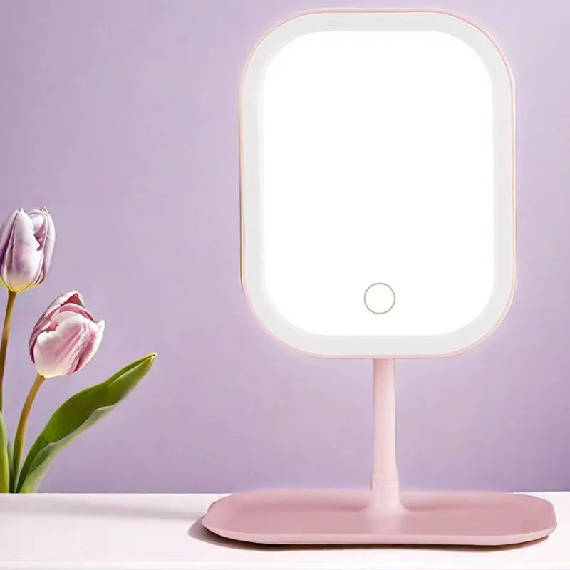 Pink vanity mirror with light on a white surface against a purple background