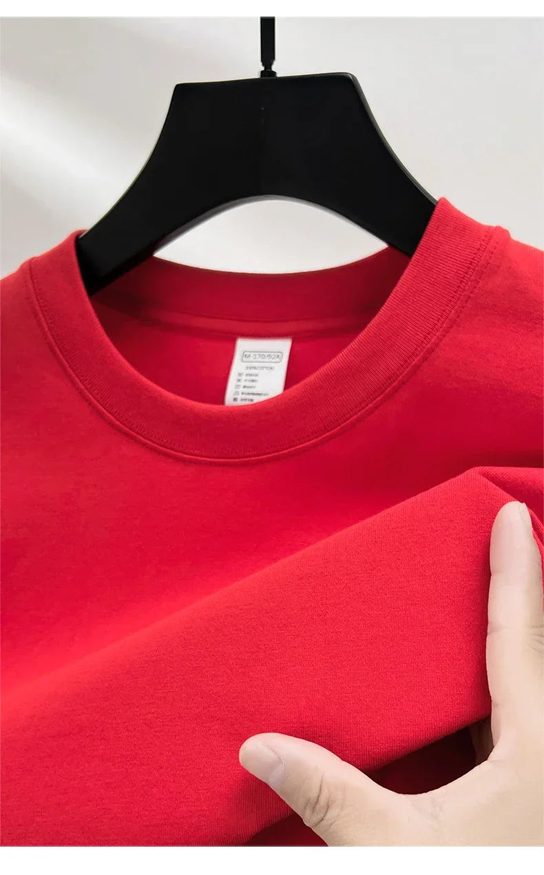 Red shirt on a hanger with a hand touching the fabric