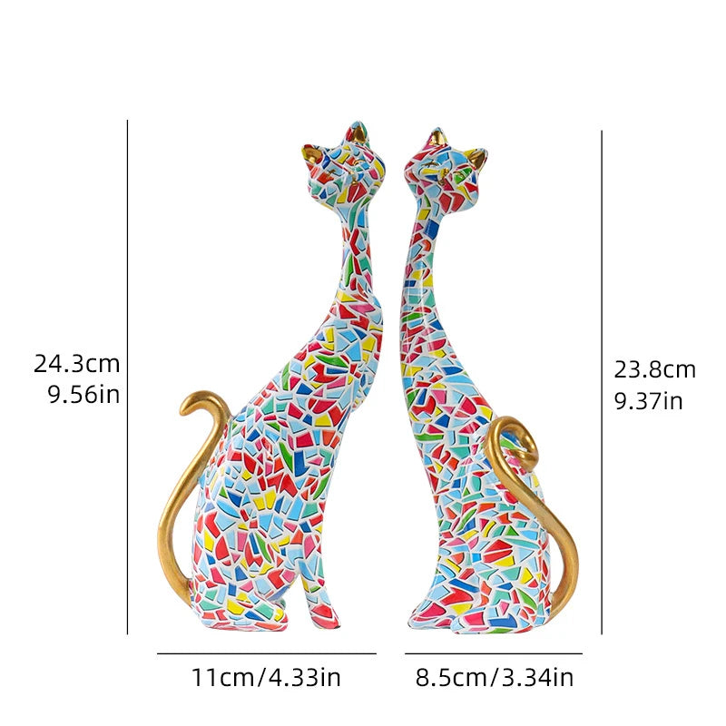 Pair of decorative resin cat sculptures with elongated modern silhouettes and artistic finishes, displayed as contemporary home decor on a tabletop.
