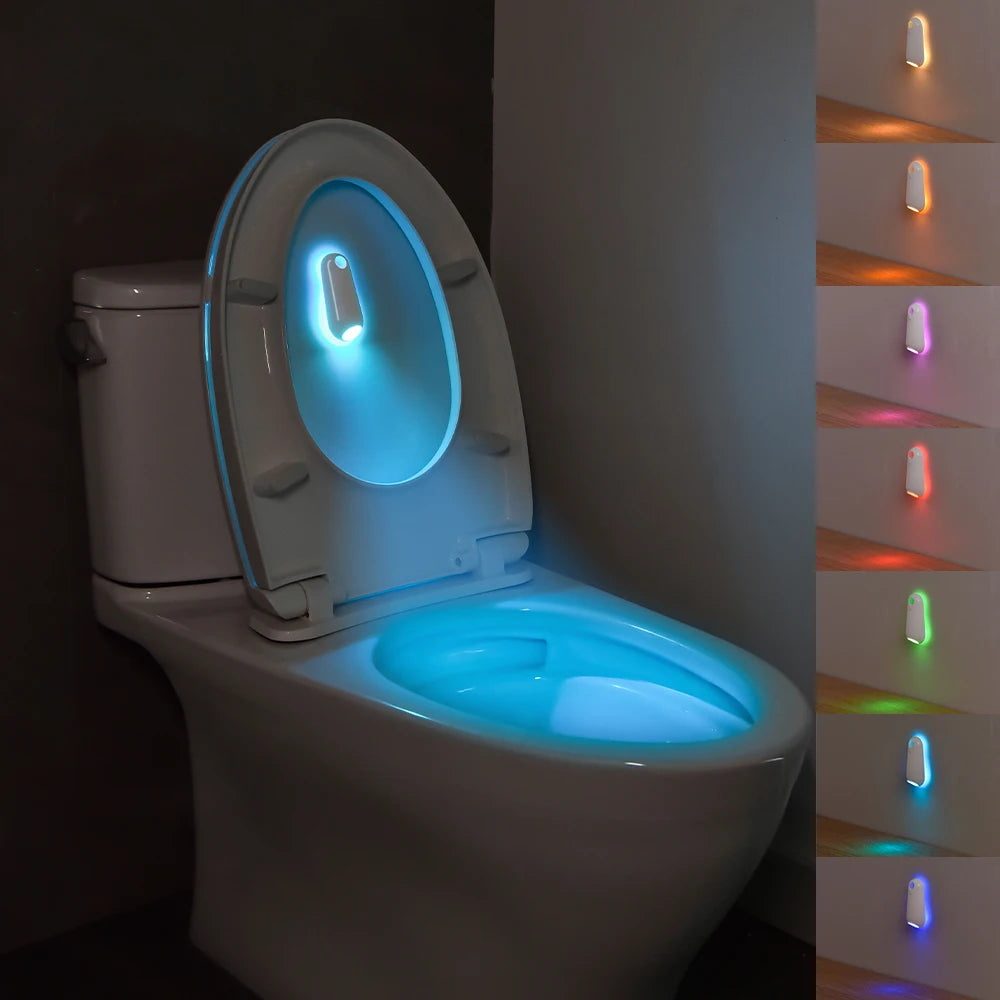 Toilet with glowing seat in a dark bathroom, showing color options on the side.