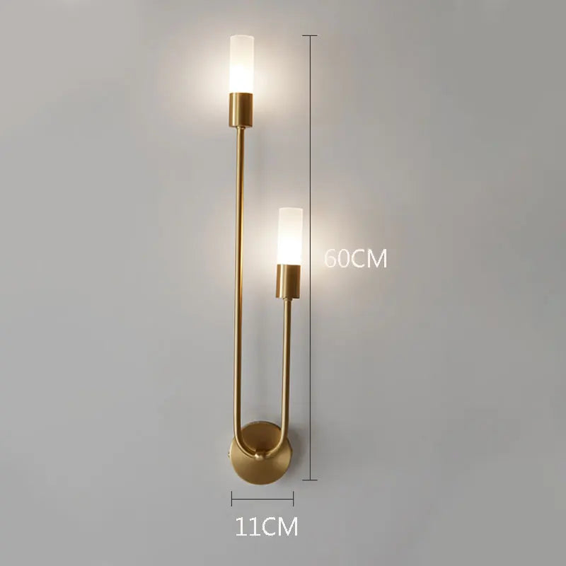 Gold wall sconce with dimensions on a gray background
