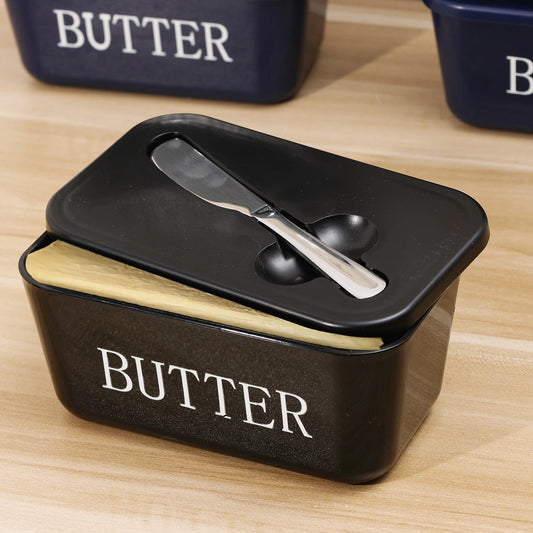 Butter container with a black lid and wooden base on a wooden surface.