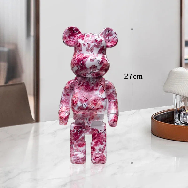 Pink and white marbled bear-like figure on a table with a measurement label