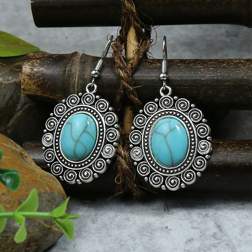 Pair of silver earrings with turquoise stones on a natural background