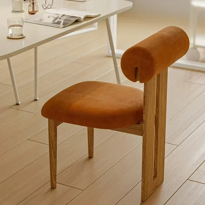 Brown chair with wooden legs on a light wood floor