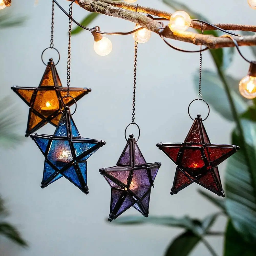 Star-shaped lanterns hanging from a branch with string lights against a natural background