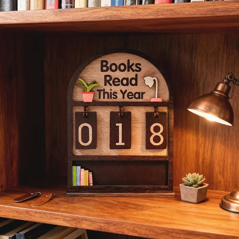 Wooden plaque with 'Books Read This Year' display on a wooden shelf with books and a lamp.