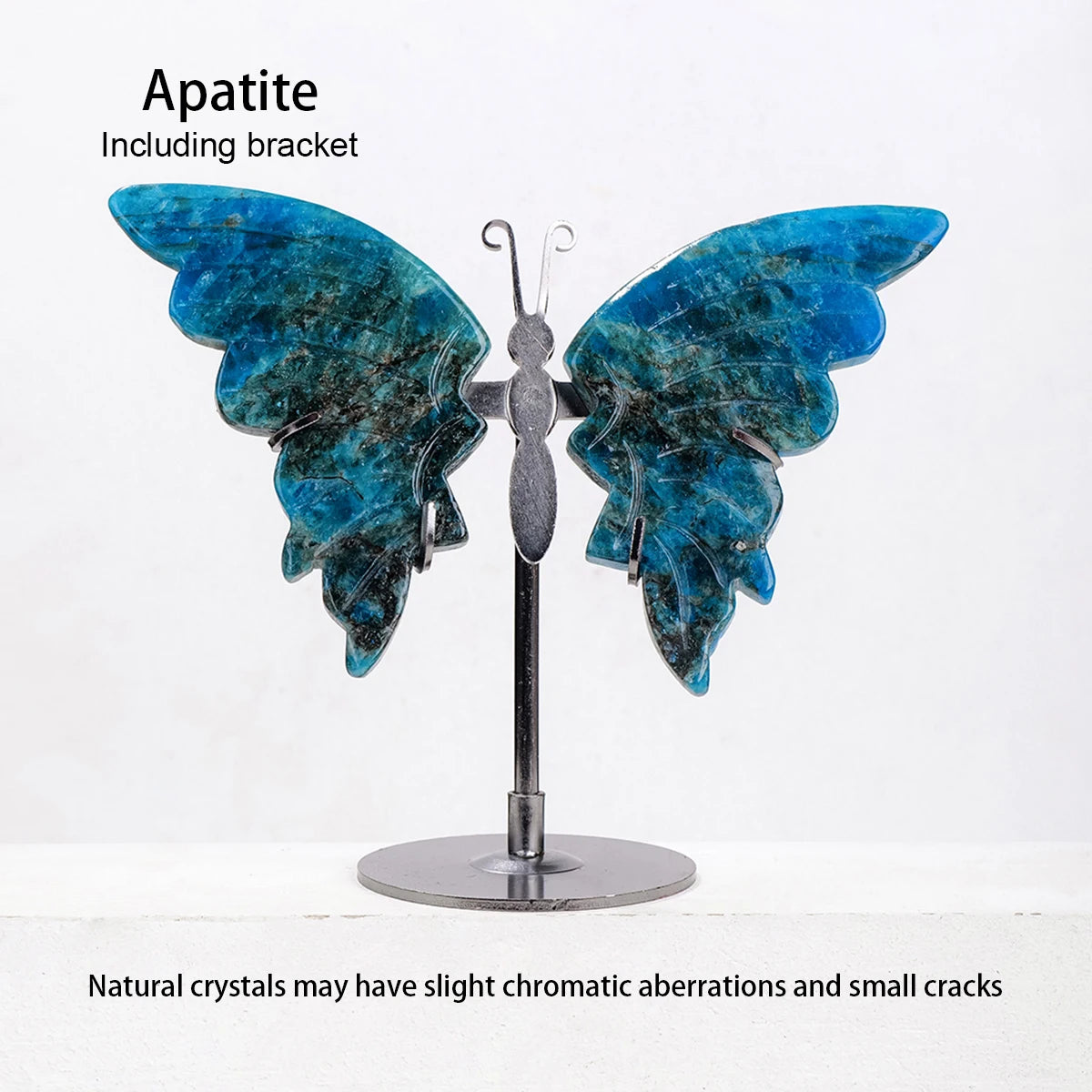 Butterfly-shaped apatite crystal with a metal bracket on a white background