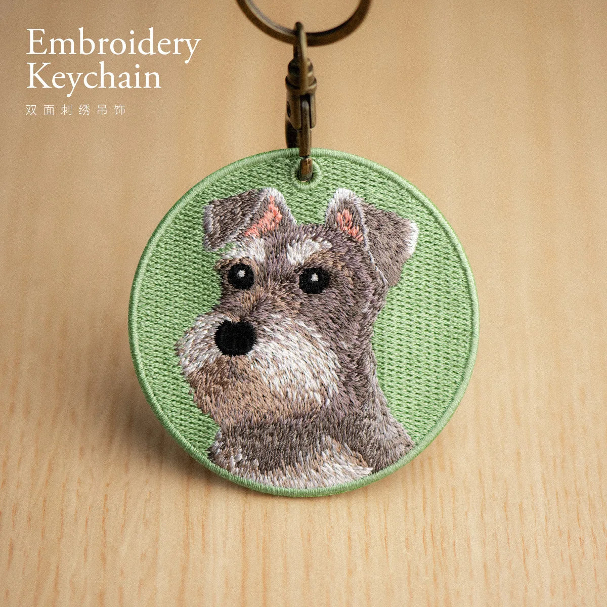 Embroidered keychain with a dog design on a wooden surface