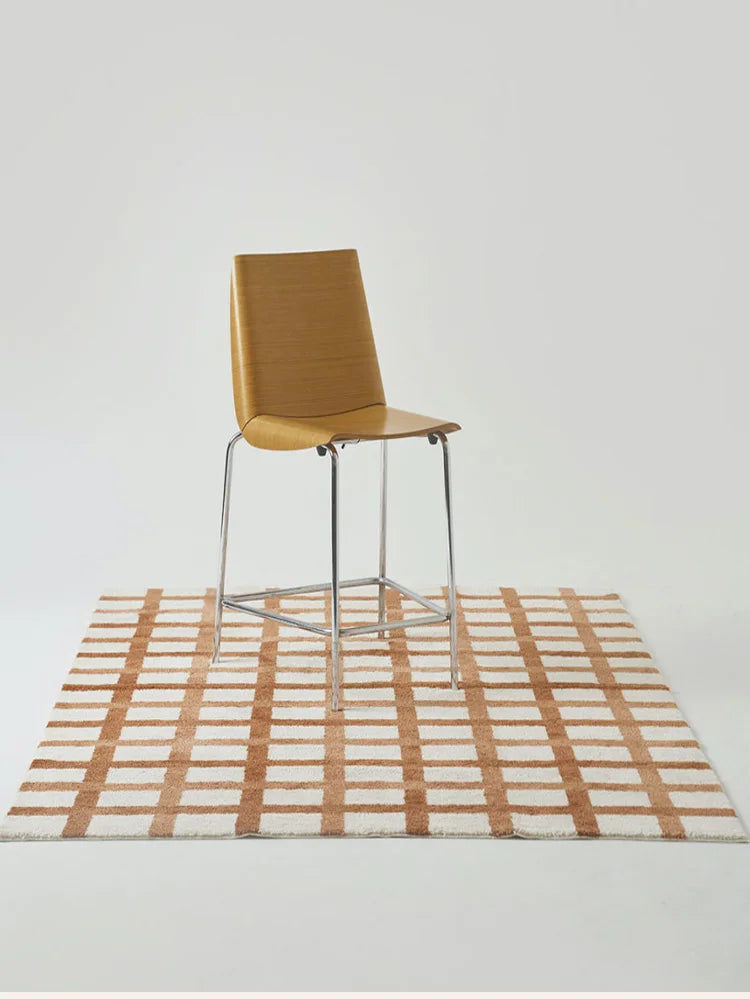 Brown chair on a checkered rug with a white background