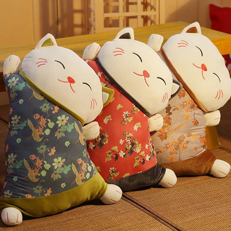 Three cat-shaped cushions with floral patterns on a wooden floor.