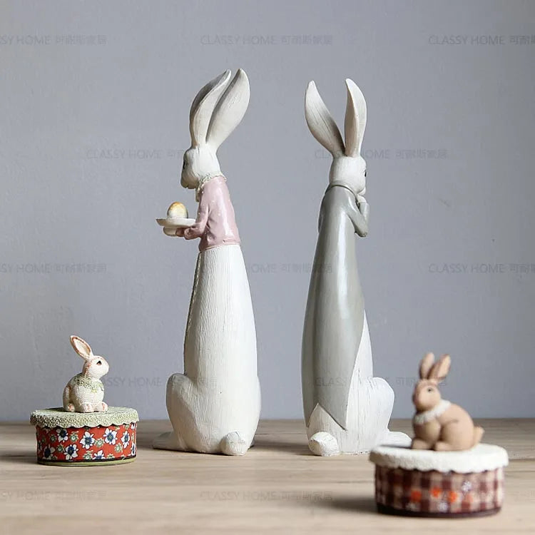Decorative rabbit figurines on a wooden surface with a plain background