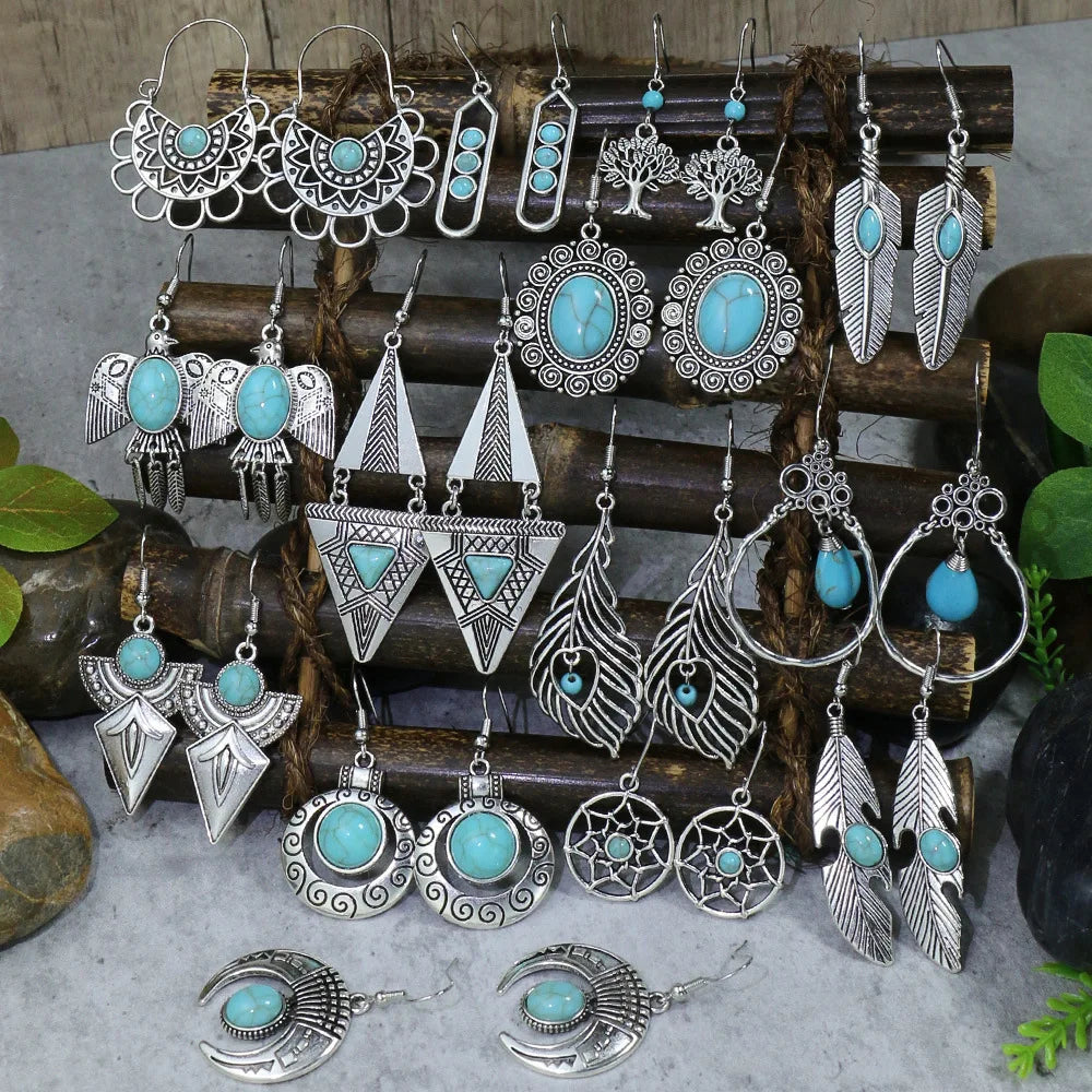 Collection of silver and turquoise earrings on a wooden stand with a natural background.