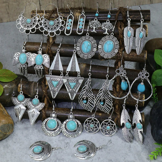 Collection of silver and turquoise earrings on a wooden stand with a natural background.