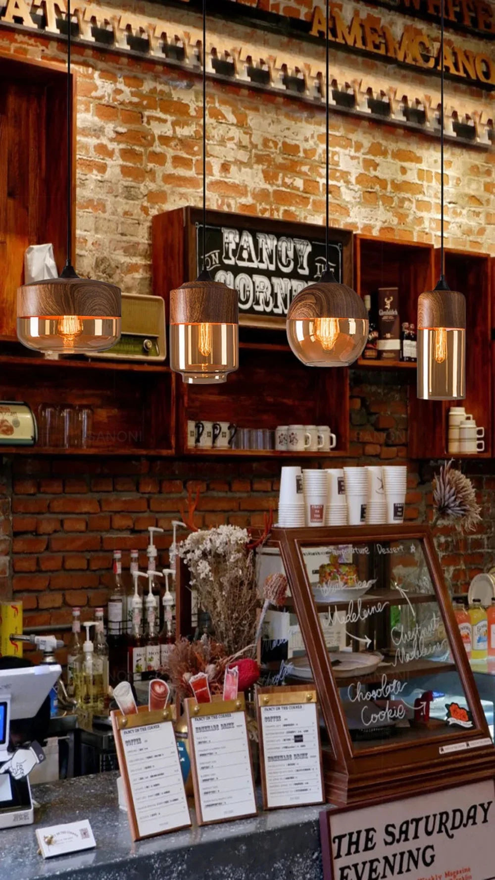 Bar area with brick wall, hanging lights, and a 'The Saturday Evening' sign.