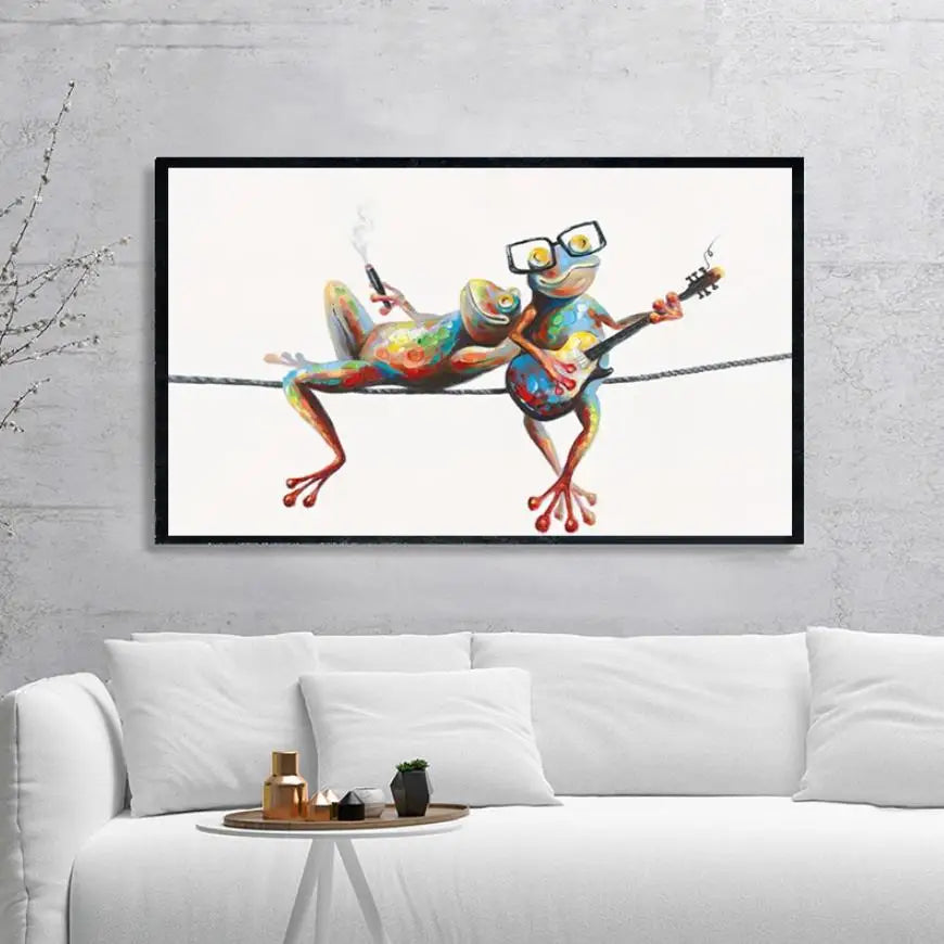 Framed artwork of colorful frogs playing guitar on a white wall above a white sofa.