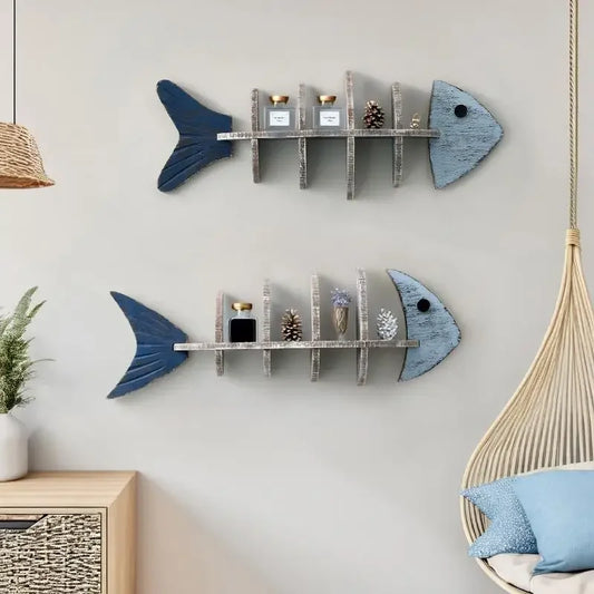 Two fish-shaped wall shelves with decorative items on a light gray wall.