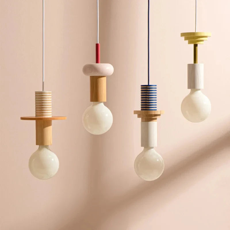 Nordic wooden pendant lights with colourful geometric details hanging against a warm neutral background