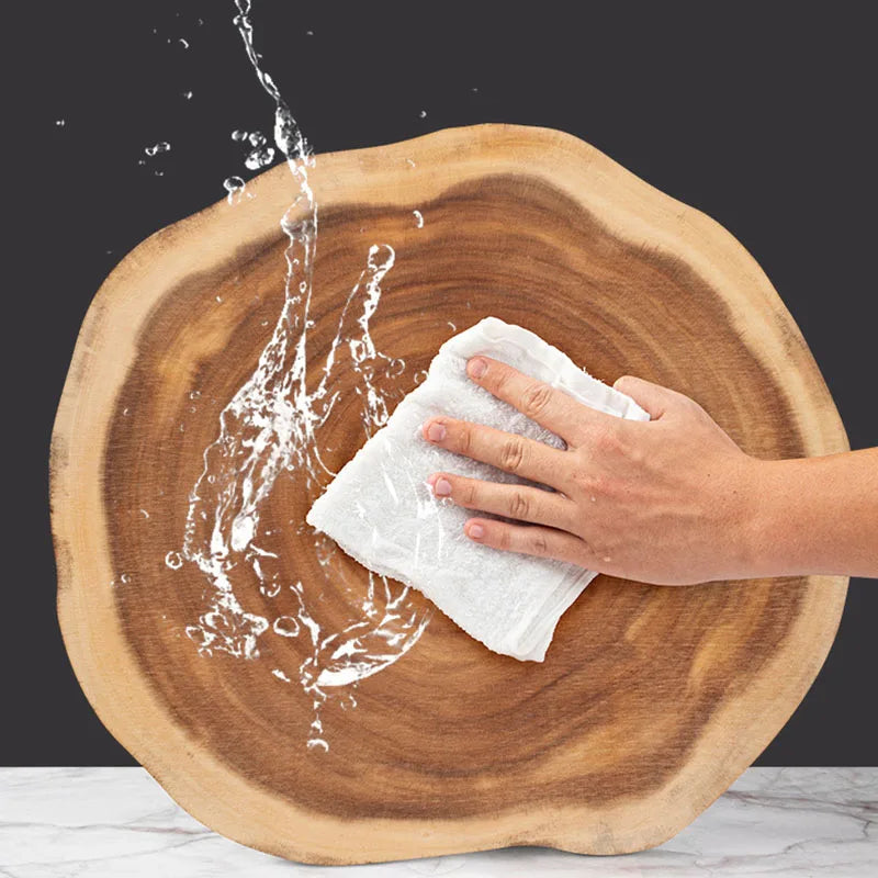 Hand cleaning a wooden surface with water splashes