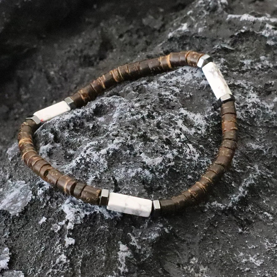 Necklace with brown and white beads on a textured stone surface