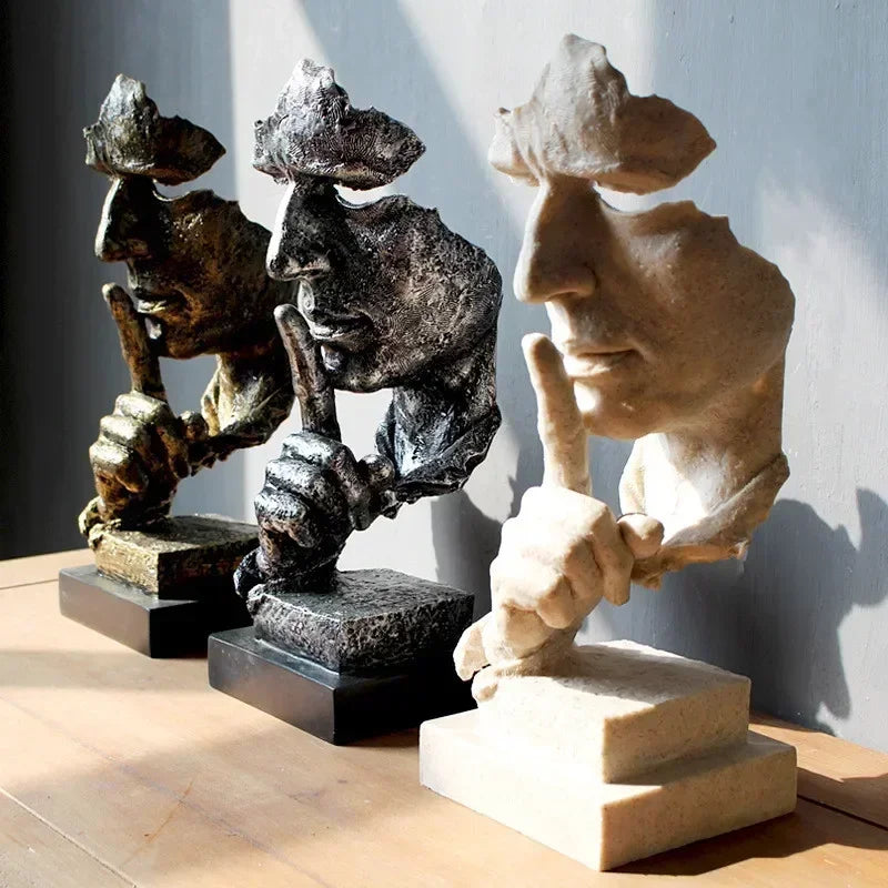 Three Art Deco-style "Dont' Speak" sculptures on a white base with a gray background