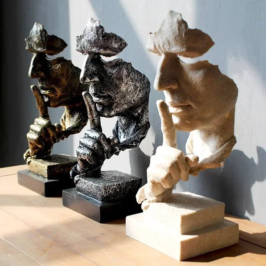 Three Art Deco-style "Dont' Speak" sculptures on a white base with a gray background