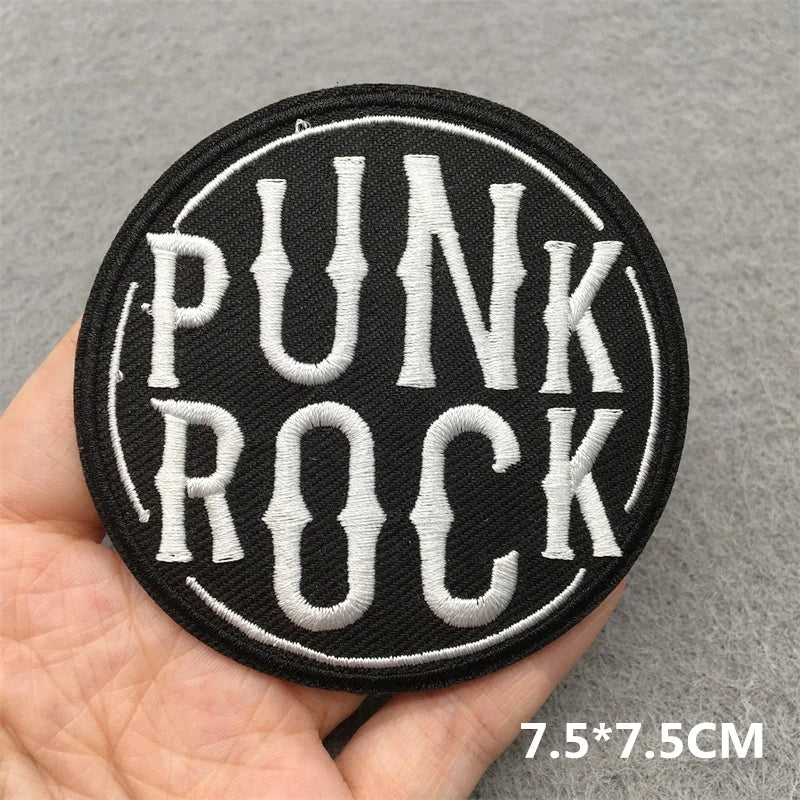 Punk Rock patch held in a hand with a gray background