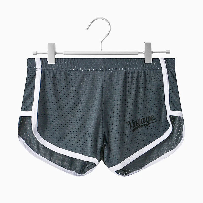Gray shorts with white trim on a hanger against a white background