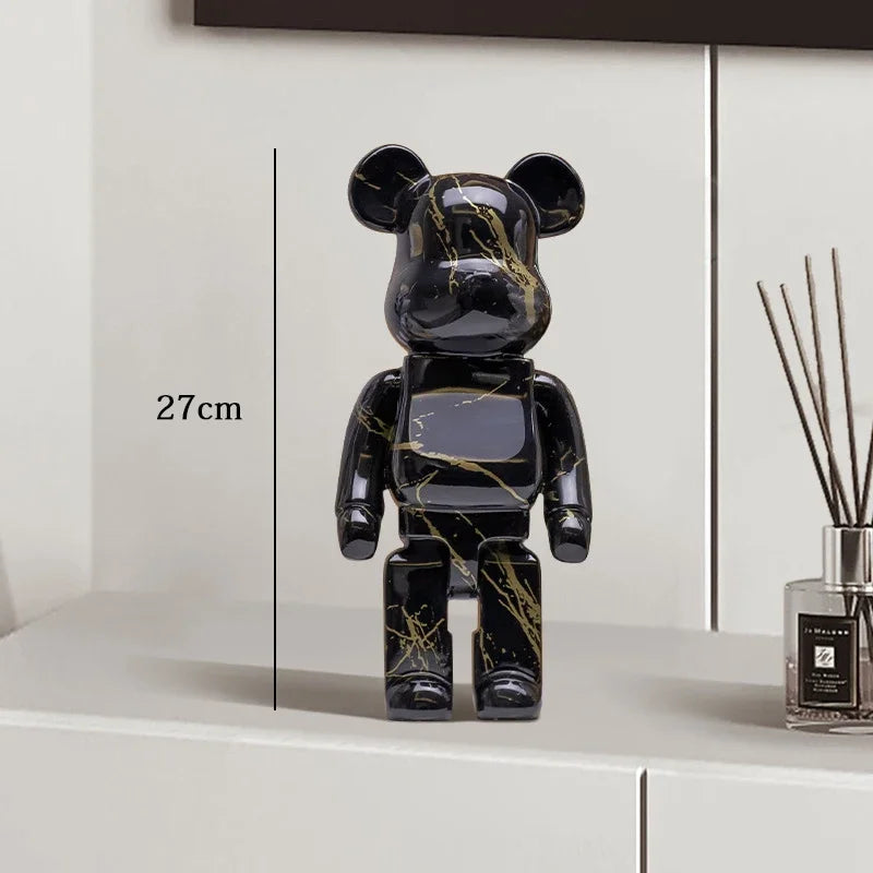 Black and gold marbled bear figure on a white surface with a diffuser in the background