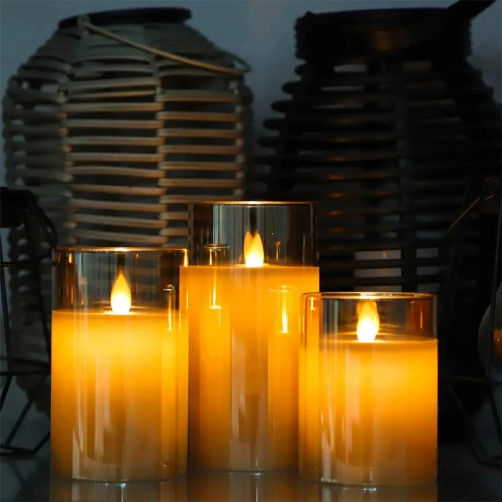 Three lit candles in glass holders with a dark background