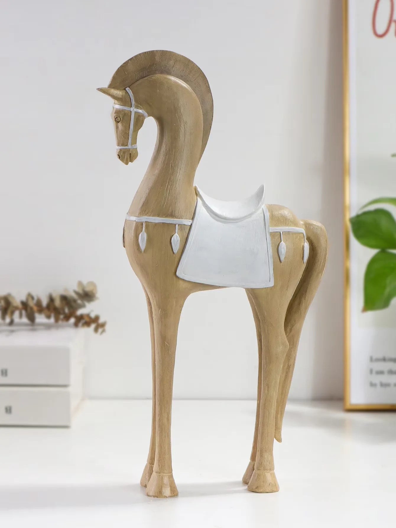 Decorative horse figure with a white saddle on a light surface.