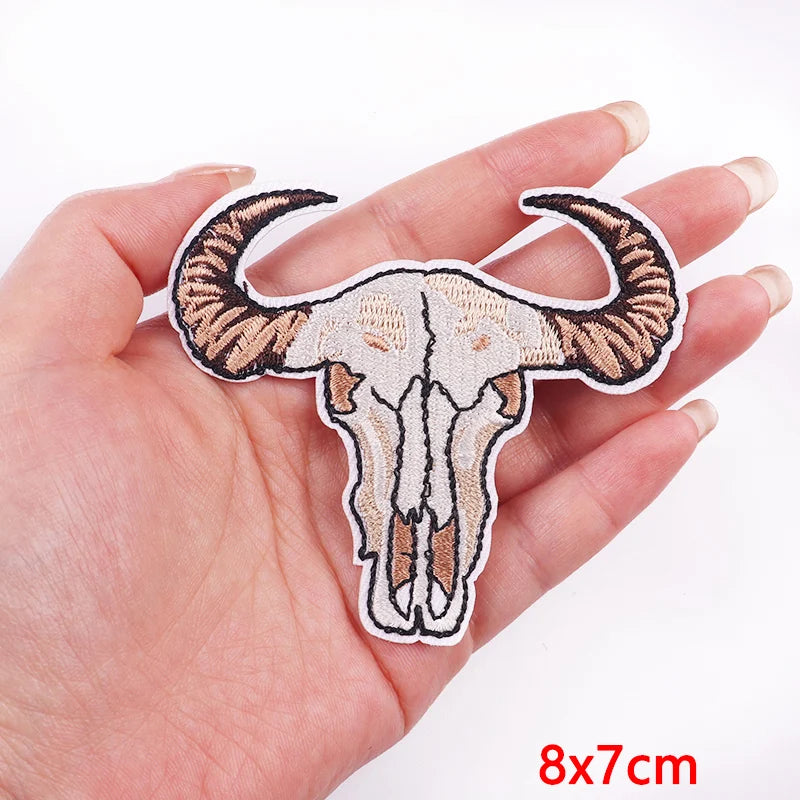 Bull skull patch held in a hand with a white background