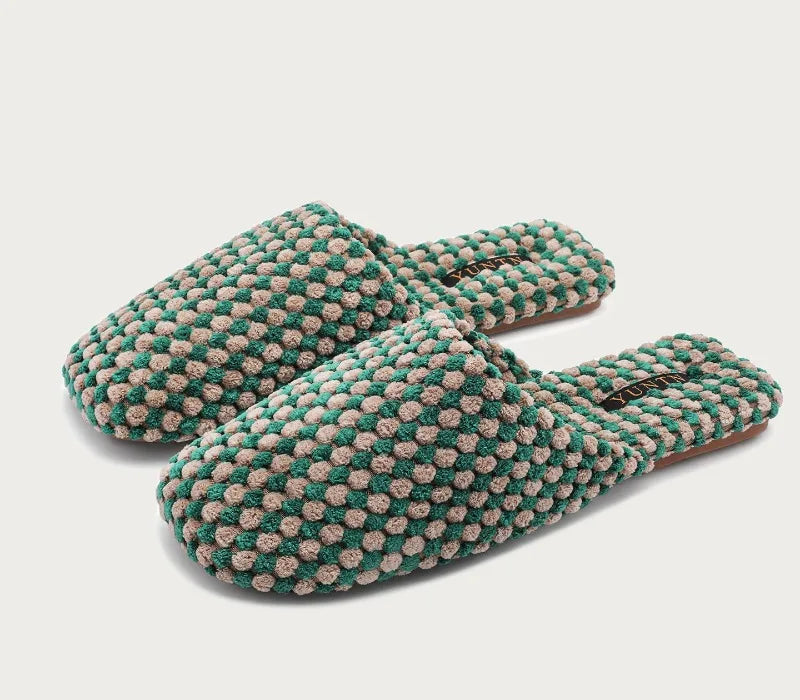 A pair of green and beige textured knit slip-on slippers shown on a light gray background with a small Chinese text label in the bottom-left corner.