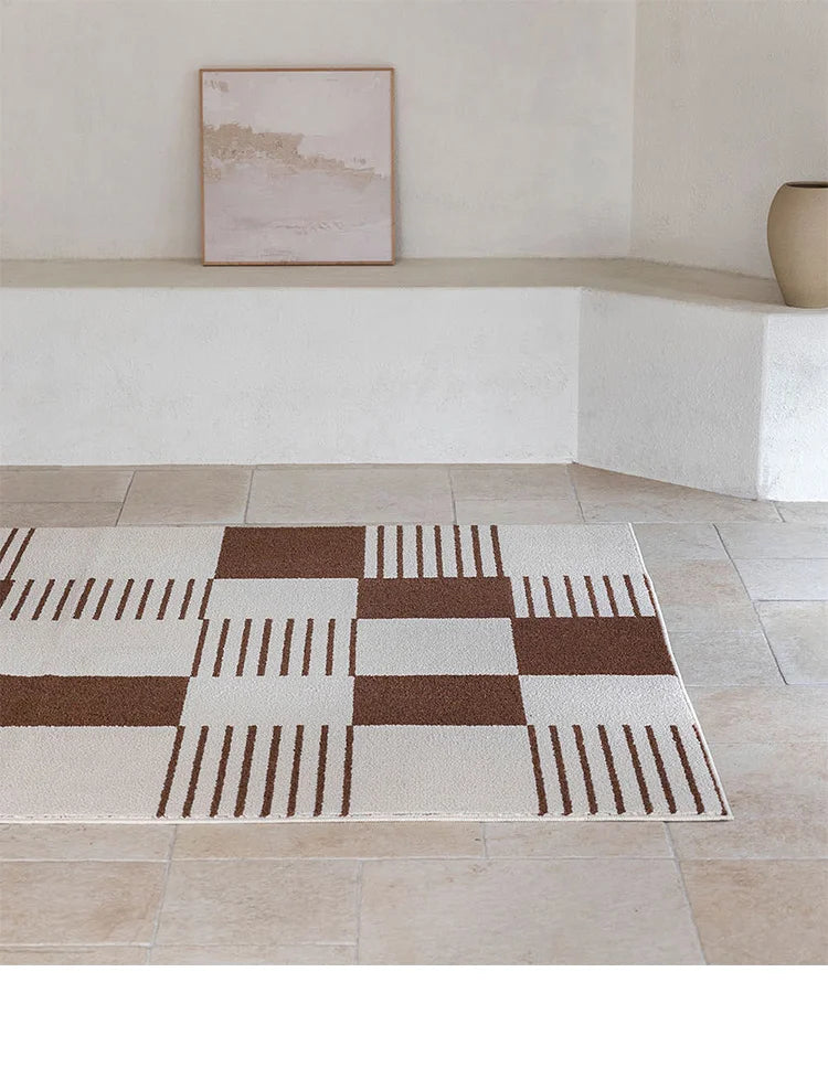 Checkered area rug with brown and beige pattern on a tiled floor.