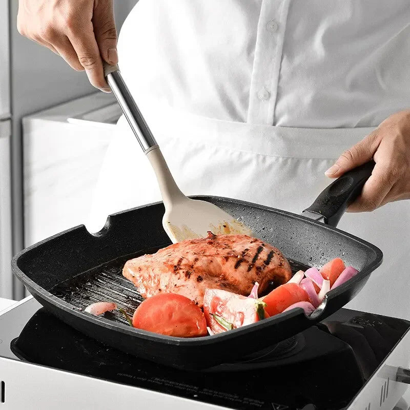 Person cooking on a stovetop with a frying pan containing food.